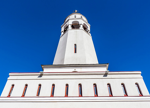 white church tower on the blue sky background