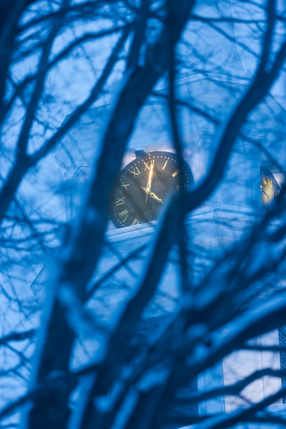 Looking through trees at a clock on the Stowe Community Church...