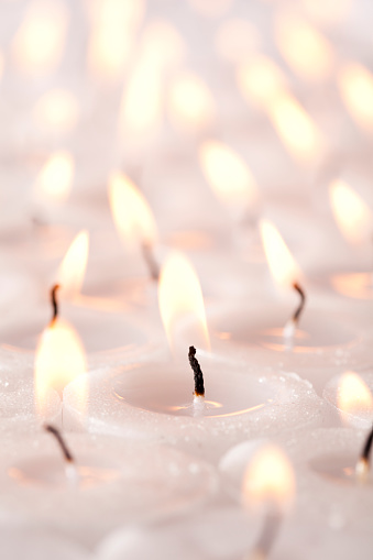 Several tea light candles arranged into a full frame image.  Reduced depth of field fading into the horizon