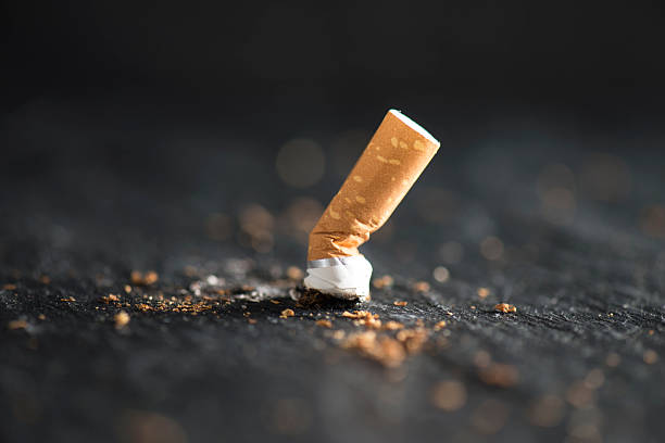Cigarette End Cigarette butt on abstract background. cigarette stock pictures, royalty-free photos & images