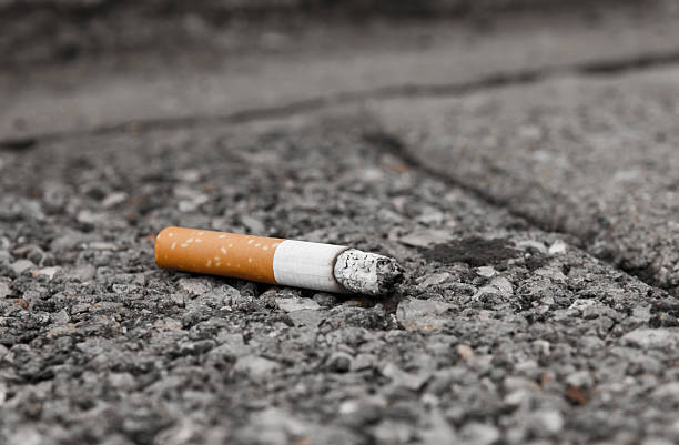 Cigarette discard a cigarette on the granit floor Smoking Kills stock pictures, royalty-free photos & images