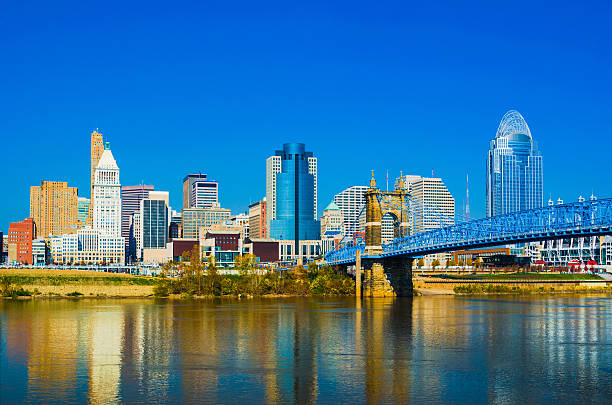Cincinnati downtown skyline and the John A. Roebling suspension bridge View of the Cincinnati downtown skyline with the John A. Roebling Bridge and the Ohio River in the foreground. cincinnati stock pictures, royalty-free photos & images