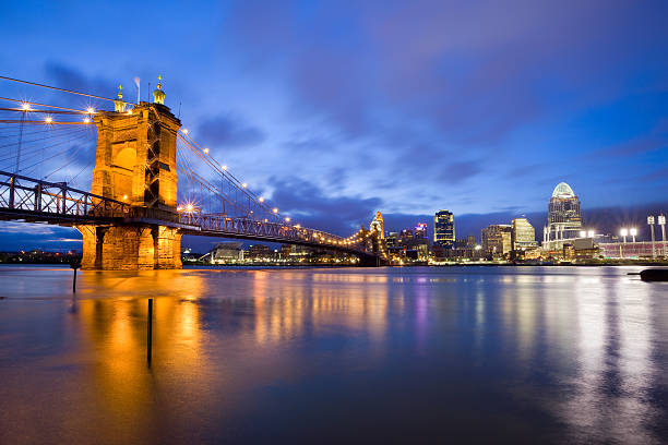 Cincinnati Ohio USA Cityscape of Cincinnati with the Roebling Suspension Bridge leading towards the downtown core and the illuminated Great American Ball Park, home of the Cincinnati Reds. cincinnati stock pictures, royalty-free photos & images