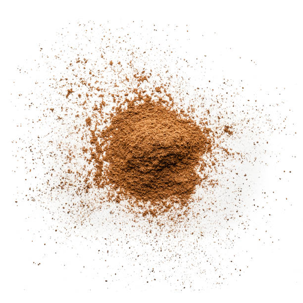 Cinnamon powder heap isolated on white background Top view of cinnamon powder heap isolated on white background. Predominant colors are brown and white. High key DSRL studio photo taken with Canon EOS 5D Mk II and Canon EF 100mm f/2.8L Macro IS USM. cinnamon stock pictures, royalty-free photos & images
