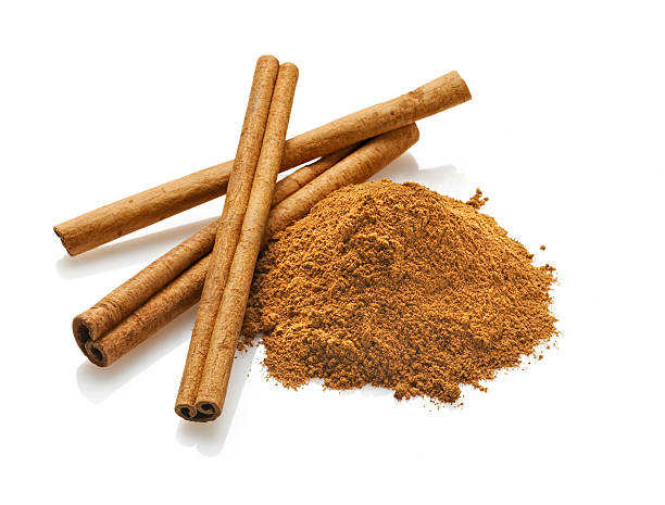 Cinnamon sticks and Powder, White Background Three cinnamon sticks next to cinnamon powder against a white plexi background with natural reflection.Shot with Nikon D3X and shift lens. cinnamon stock pictures, royalty-free photos & images