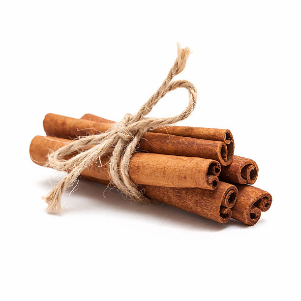 Cinnamon sticks Five cinnamon sticks tied by rope isolated on white background. cinnamon stock pictures, royalty-free photos & images