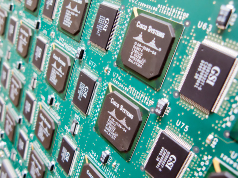 Amsterdam, The Netherlands - June 26, 2009: Circuit board close up, electronic components mounted on green cuircuit board.