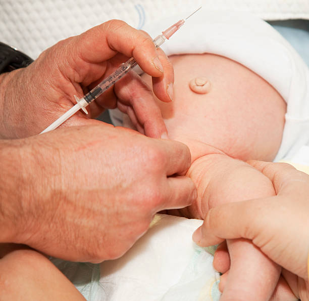 Circumcision on newborn baby in progress stock photo