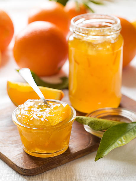 Citrus jam on wooden cutting board Citrus jam in glass jar, selective focus marmalade stock pictures, royalty-free photos & images
