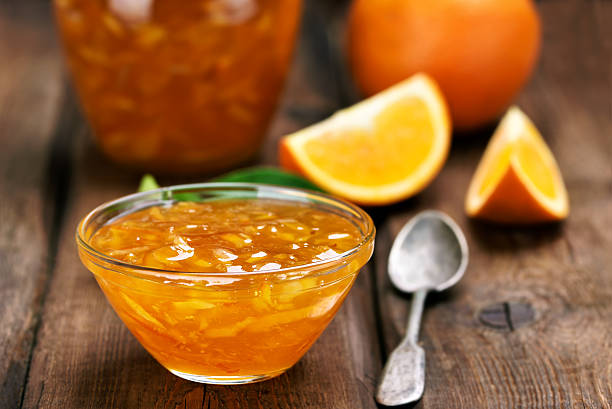 Citrus orange jam Orange jam on wooden table, focus on jam in bowl, shallow depth of field marmalade stock pictures, royalty-free photos & images
