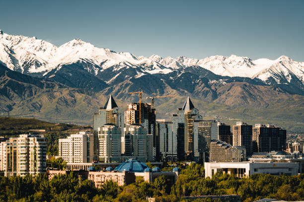 City landscape on a background of snow-capped Tian Shan mountains in Almaty Kazakhstan City landscape on a background of snow-capped Tian Shan mountains. The complex of buildings along Al-Farabi avenue. Photo taken in Almaty, Kazakhstan. kazakhstan stock pictures, royalty-free photos & images