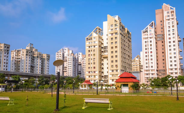 City public park surrounded by tall residential buildings with view of city over bridge at Rajarhat area of Kolkata, India stock photo