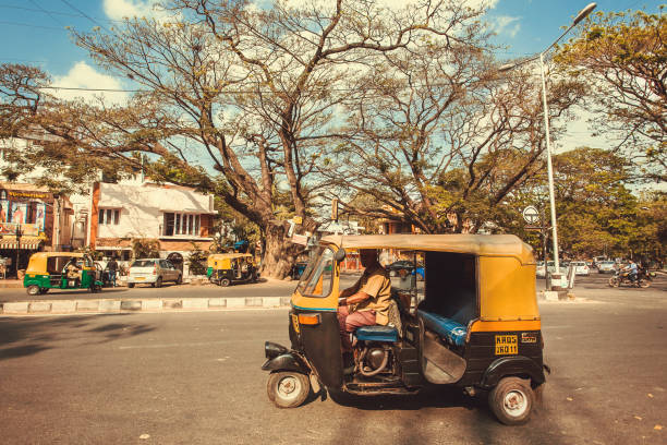 City road with driving indian taxi autorickshaw stock photo