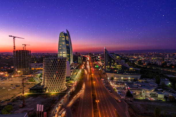 stadtverkehr langzeitbelichtung corporate night air view drohne aufnahme von finanz-geschäftsviertel in sofia, bulgaira bei sonnenuntergang - bulgarien stock-fotos und bilder