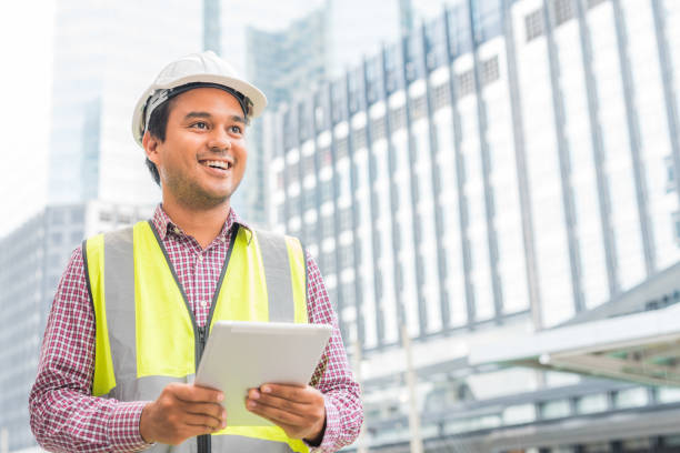 Civil engineering using tablet while working on building construction site. stock photo
