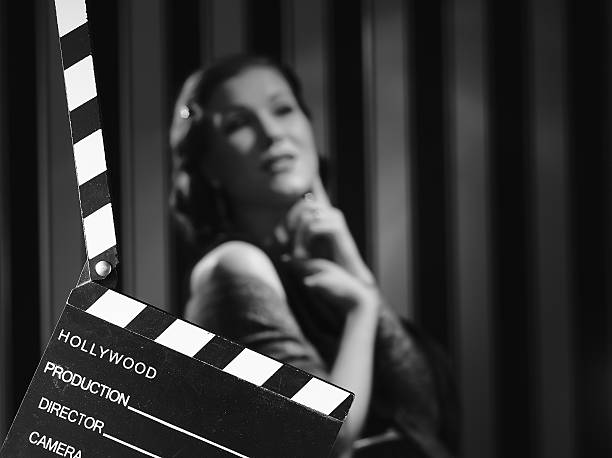 Clapboard in front of a black and white image of actress Hollywood black and white, a beautiful acting woman and a clapboard - minimal lighting and strong contrast actress stock pictures, royalty-free photos & images