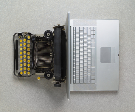Early 20th Century typewriter vs early 21st Century laptop; back to back
