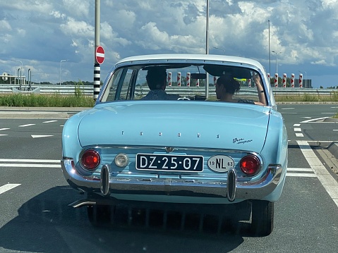 Schinnen, the Netherlands, - July 25, 2021. Classic 1963 Ford Taunus making a weekend trip  on the highway.