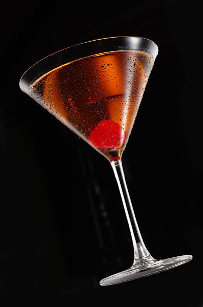 Classic manhattan martini A classic manhattan cocktail photographed from a low angle on a black background manhattan cocktail stock pictures, royalty-free photos & images