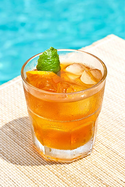 Classic Old Fashioned cocktail near waterpool on the mat stock photo