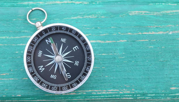 klassische runde kompass auf grünen holz vintage hintergrund - kompass fotos stock-fotos und bilder