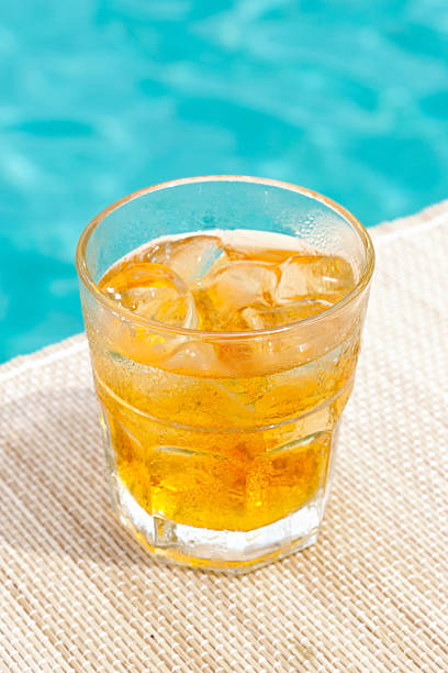Classic rusty nail cocktail near waterpool on the mat stock photo