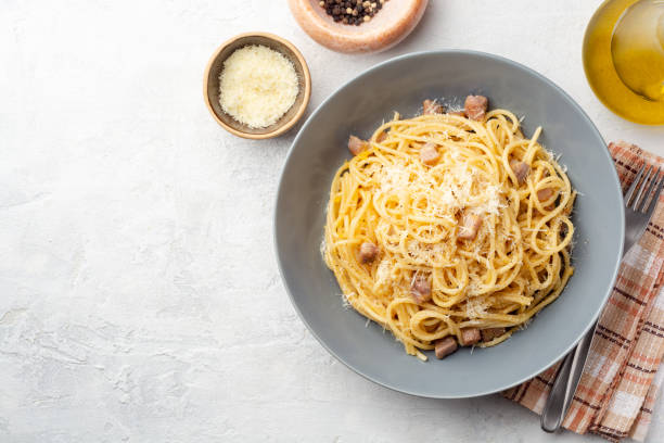 Classic spaghetti pasta carbonara with pancetta, egg yolk and parmesan cheese on concrete background stock photo