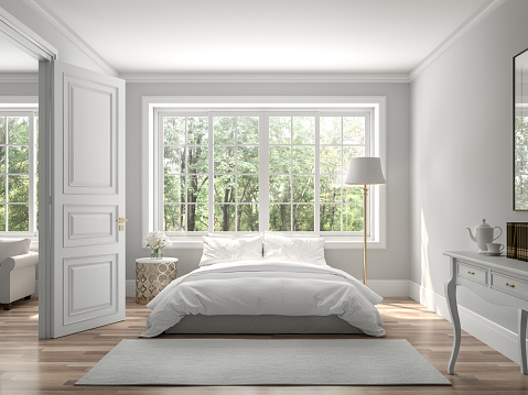 Classical bedroom and living room 3d render,The rooms have wooden floors and gray walls ,decorate with white and gold furniture,There are large window looking out to the nature view.