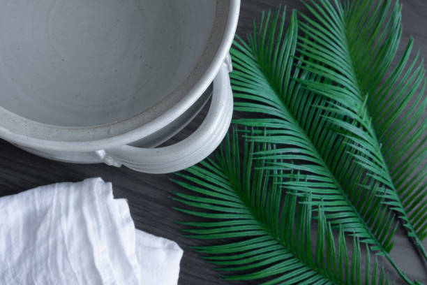 Clay pot of water, palm leaves and white linen stock photo