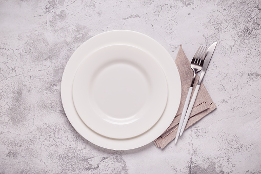 Clean empty white plate with cutlery. Copy space, mock up, top view. Concept for menu with utensil.