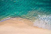 istock Clean ocean waves breaking on white sand beach with turquoise emerald coloured water 1302343043