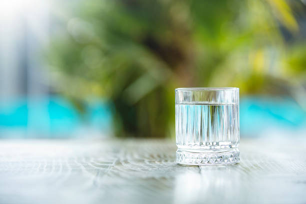 Clean water in small glass on table stock photo