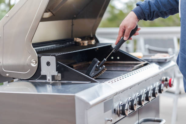 Cleaning outdoor gas grill stock photo