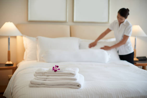 Cleaning room Maid cleaning bedroom after guests, focus of clean towels maid stock pictures, royalty-free photos & images
