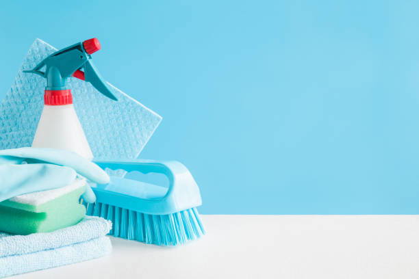 Cleaning set for different surfaces in kitchen, bathroom and other rooms. Empty place for text or logo on blue background. Cleaning service concept. Early spring regular clean up. Front view.  cleaning product stock pictures, royalty-free photos & images