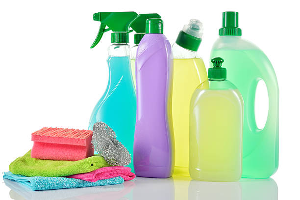 Cleaning sprays and bottles with pile of sponges and cloths stock photo