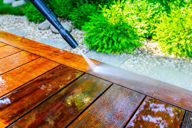 cleaning the terrace with a pressure washer - high-pressure cleaner on the wooden surface of the terrace - very shallow depth of field - sharpness on the terrace board under a stream of water stock photo
