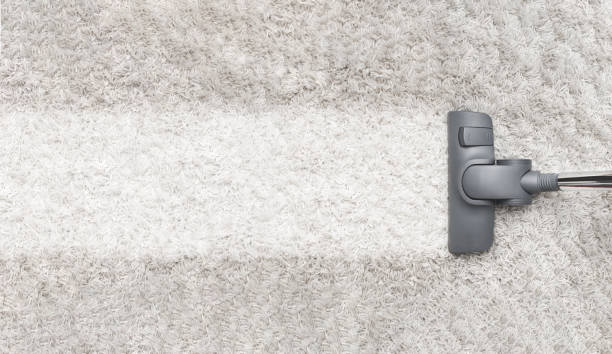Cleaning white carpet with vacuum cleaner stock photo