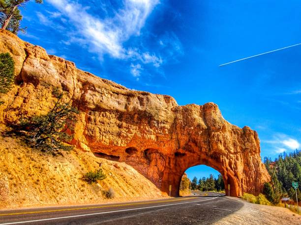 Clear sky at Redrock Arch Tunnel Bryce Canyon National Park Utah Passing through Redrock Arch Tunnel in Red Canyon Road Bryce Canyon National Park Utah bryce canyon national park stock pictures, royalty-free photos & images