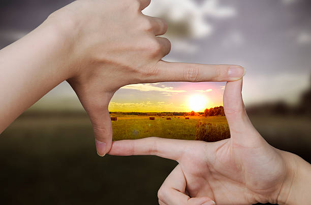clear vision of a sunset out of focus nature and fingers creating a square making the scenery better image focus technique stock pictures, royalty-free photos & images