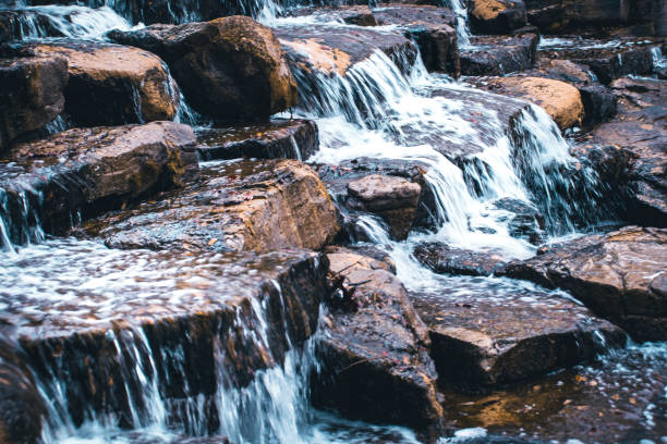 Clear Water Flowing Over Rocks Creating A Peaceful Calm Waterfall stock photo