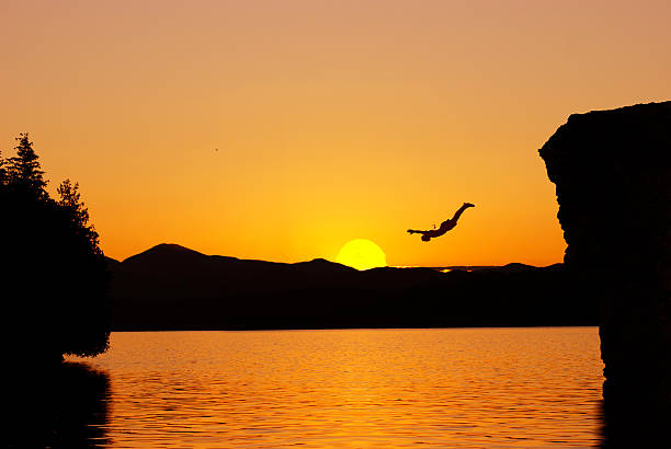 cliff diving cliff diving at sunset cliff jumping stock pictures, royalty-free photos & images