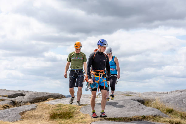Climbing learners following their climbing instructor in rough terrain stock photo