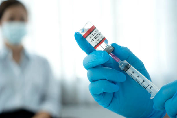 Close up a vial of covid-19 vaccine in hand of a scientist or doctor stock photo