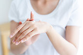 毎日のライフスタイルの概念のために朝に皮膚に適用する上で保湿剤やUV保護クリームを使用して大人の女性の手をクローズアップ