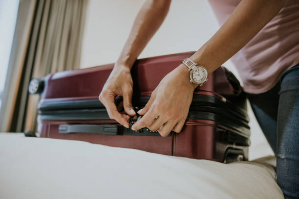 Close up Asian female traveler unlock her baggage. stock photo