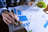 istock Close up businessman using calculator and reading paper document about business data, accountancy document, graph profit company. 1320806352