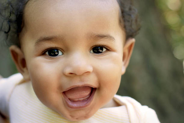 Close up cute African American baby outdoors "Cute smiling baby of African descent, looking at camera - close up." babies only stock pictures, royalty-free photos & images