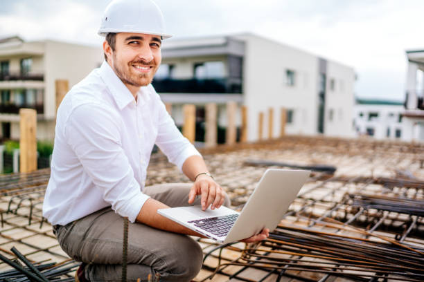 Close up details of architect using laptop on building construction site stock photo