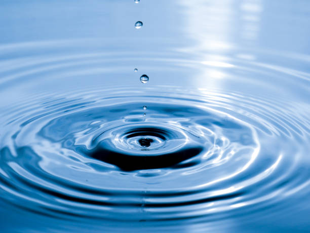 close up drop of water on blue background stock photo